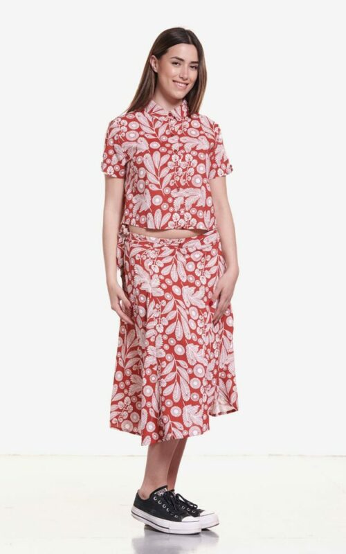 Falda midi con estampado vegetal en blanco en fondo color ladrillo rojizo.